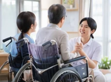 車いすの利用者と笑顔で話す介護スタッフ